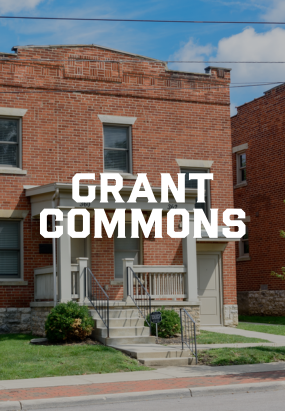 Red brick building with a small porch and steps, labeled Grant Commons in bold white text over the image—a classic choice among Columbus apartments.