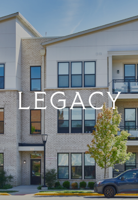 A modern three-story Columbus apartments building with large windows, a small tree in front, and the word LEGACY centered over the image.