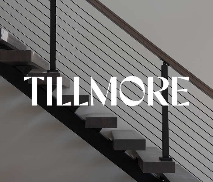 Discover the modern sophistication of Columbus apartments with this stunning staircase, boasting wooden steps and a sleek metal railing, accented by the bold TILLMORE design.
