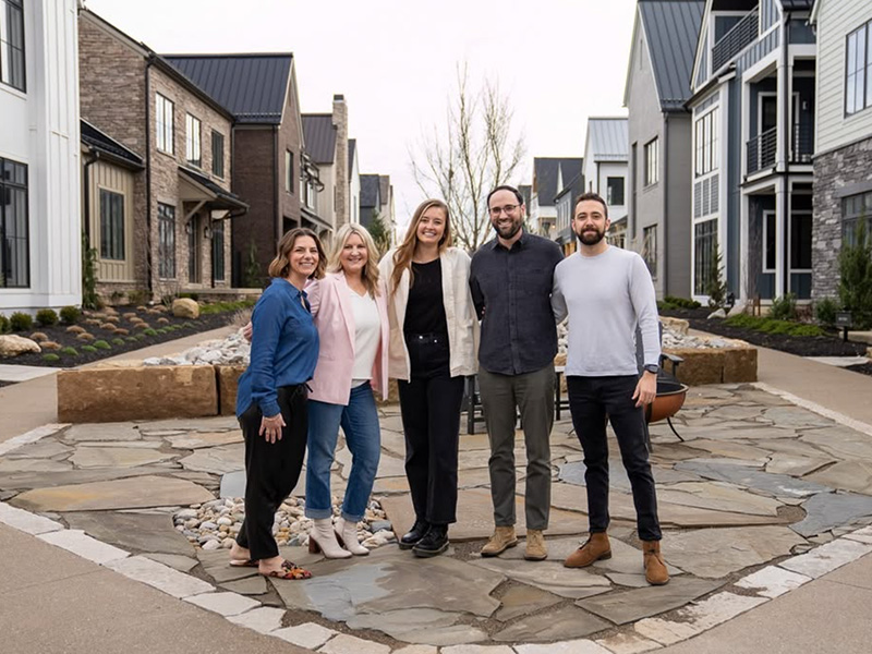 Thrive Realty team in front of a courtyard of homes