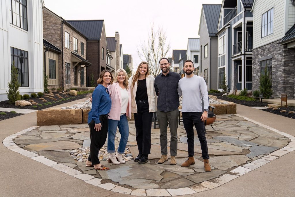 Thrive Realty team in front of a courtyard of homes