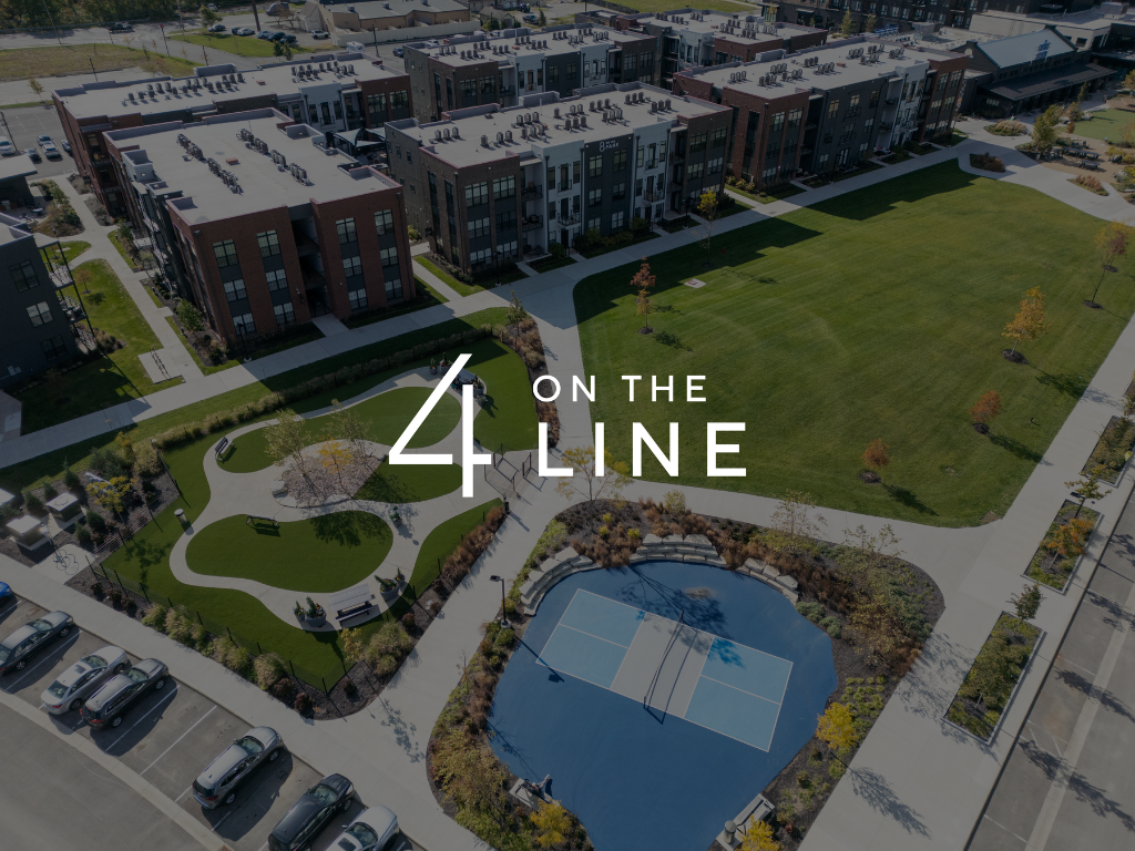 Thrive Companies, Aerial view of apartment buildings, a large green lawn, a walking path, a blue half basketball court, and a parking lot; 4 On The Line text overlay. Apartments in Columbus Ohio