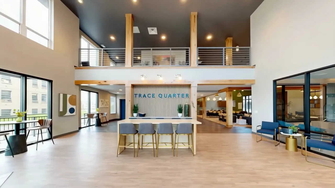 Thrive Companies, Spacious apartment building lobby with a central bar, lofted mezzanine, and seating areas. Apartments in Columbus Ohio