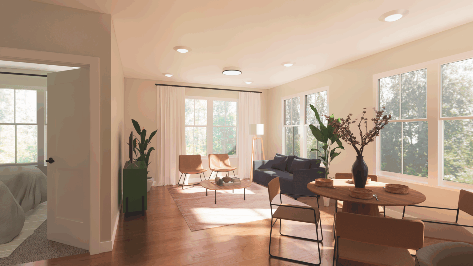 A modern living and dining area at The Michael at GVX features large windows, wooden floors, neutral furniture, potted plants, and a bedroom visible through an open door.