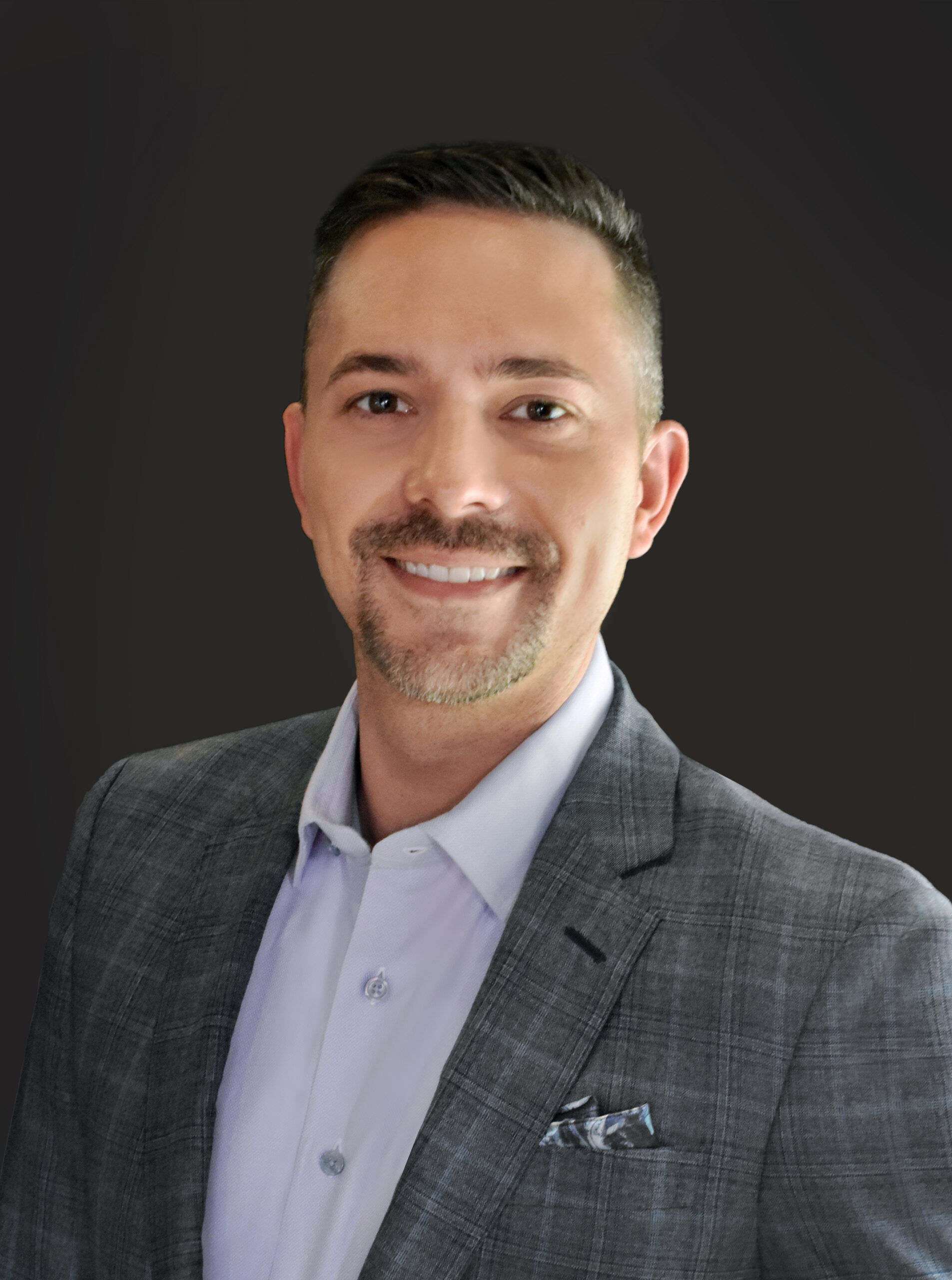 Thrive Companies, A member of Our Team, this man wears a gray suit jacket and light-colored shirt, smiling as he poses in front of a plain dark background. Apartments in Columbus Ohio