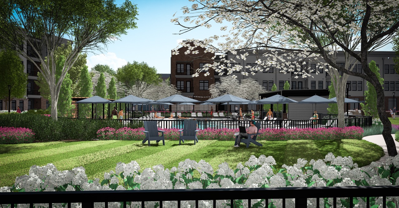 Thrive Companies, People relax on a grassy lawn and patio surrounded by blooming trees and flowers, with the modern Moore’s Edge apartment building in the background. Apartments in Columbus Ohio