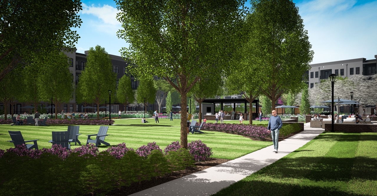Thrive Companies, People walk and sit in a landscaped park area with trees, grass, flowers, and outdoor seating at Moore’s Edge, surrounded by multi-story apartment buildings under a blue sky. Apartments in Columbus Ohio