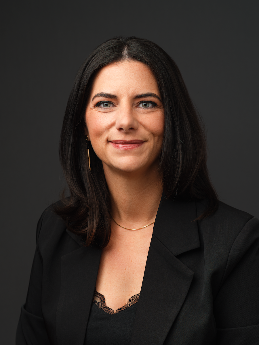 Thrive Companies, A member of Our Team, this woman with long dark hair wears a black blazer and lace-trimmed top, smiling slightly against a plain dark background. Apartments in Columbus Ohio