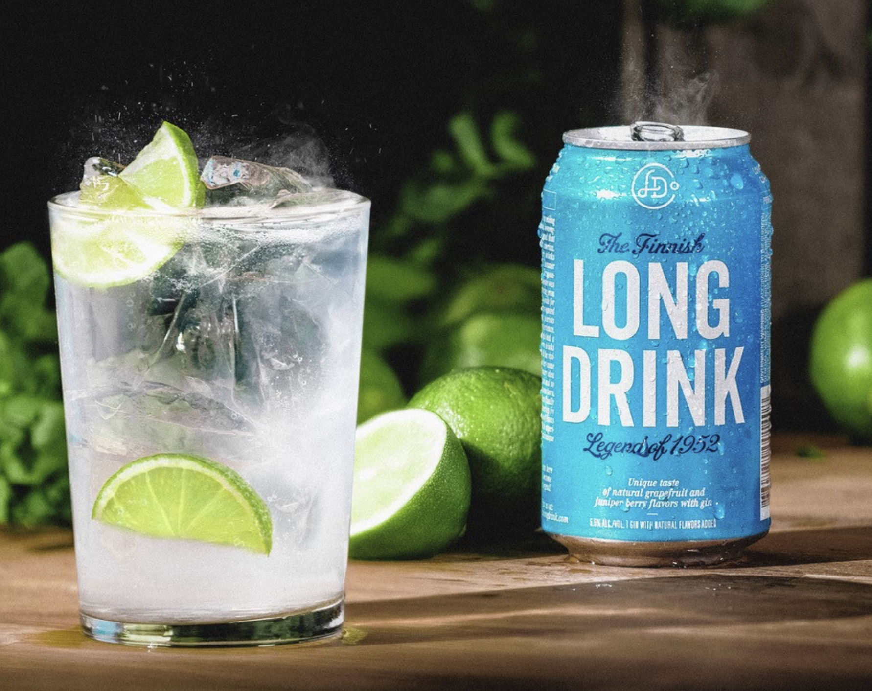 Thrive Companies, A can of The Finnish Long Drink, our proud sponsor, sits next to a glass filled with ice, clear liquid, and lime wedges on a wooden surface with whole limes in the background. Apartments in Columbus Ohio