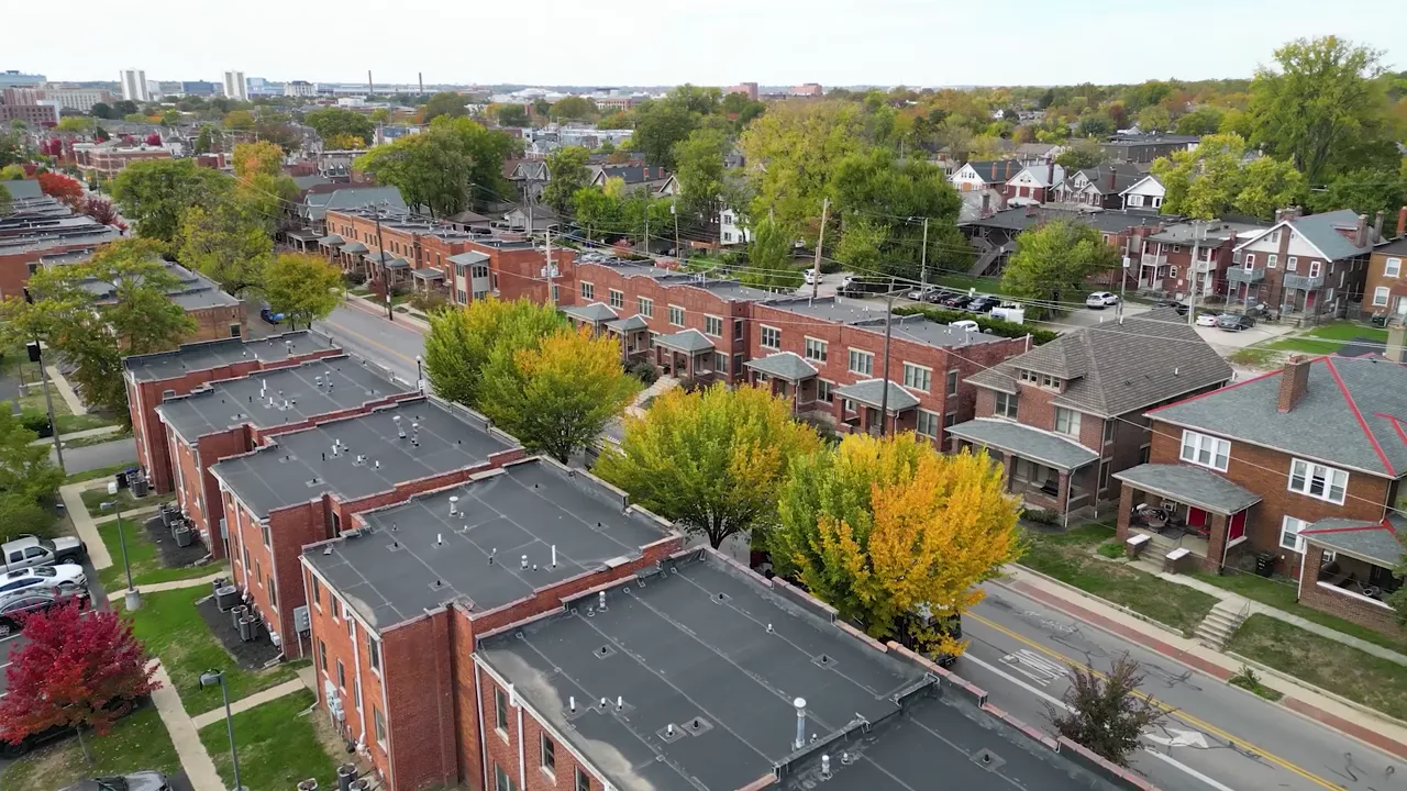 Thrive Companies, Aerial view of a residential city street lined with brick Weinland Park apartment row houses and trees with autumn foliage. Apartments in Columbus Ohio